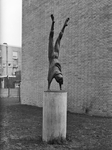 87220 Afbeelding van het door Jan van Luyn in 1963 in bronsvervaardigde beeld 'Jongen in handstand' bij de Dr. De ...